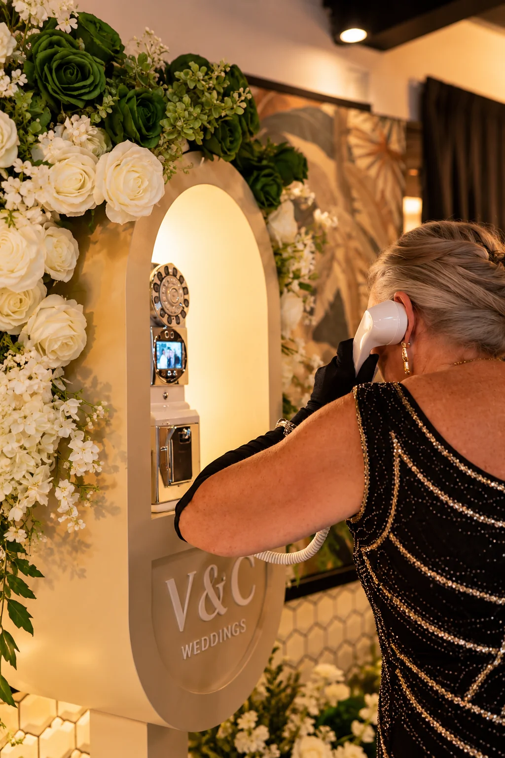 Wedding guest in a black dress using the telephone guest book
